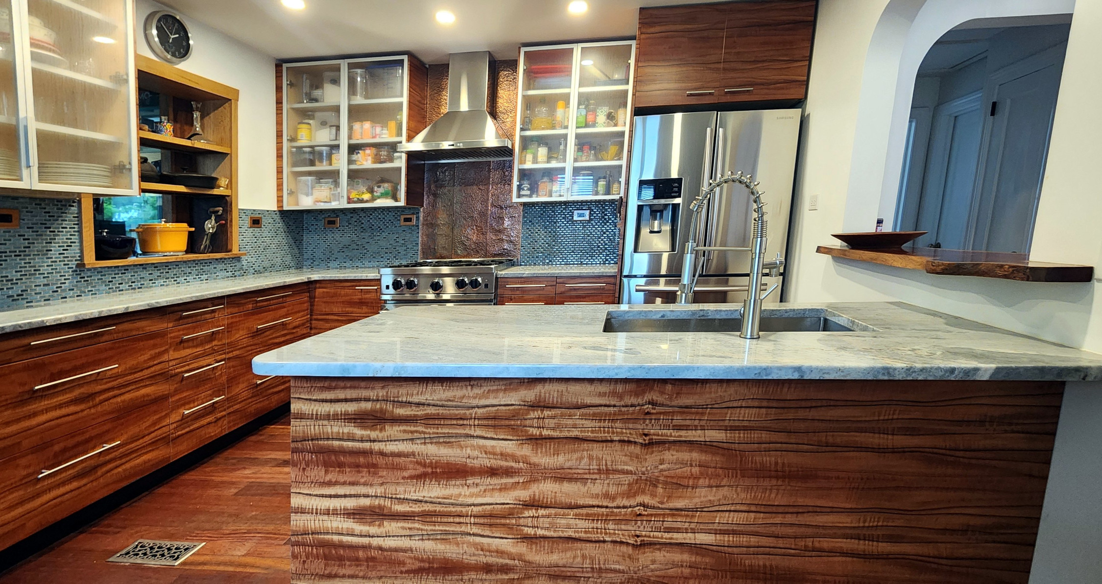 Full kitchen with figured koa cabinetry and marble island